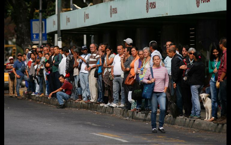Personas aguardan el transporte público este viernes en la capital venezolana.