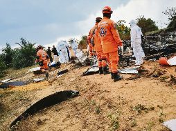 Socorristas y personal forense analiza los restos del aparato de fabricación estadounidense. AFP