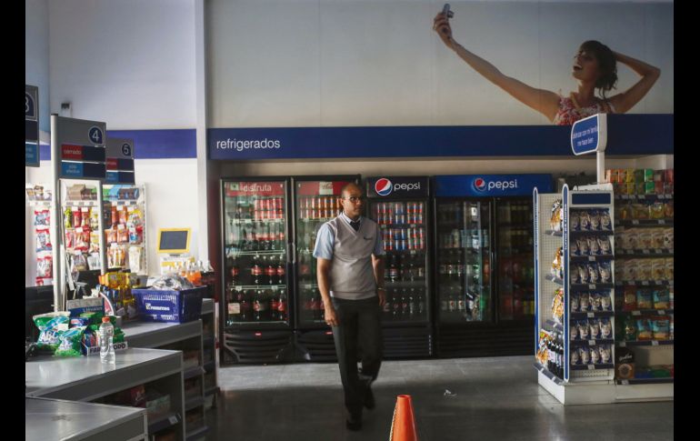 Un empleado entra a una tienda durante el apagón en Caracas. AFP