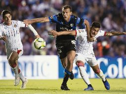 Isaac Brizuela y Alexis Vega, de Chivas, intentan superar la marca de Diego Novaretti, de los Gallos, durante el juego de ayer en Querétaro. MEXSPORT