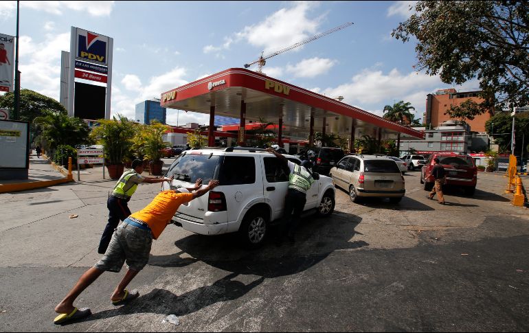 Habitantes empujan un auto a una de las pocas gasolineras que cuenta con un generador eléctrico en Caracas, Venezuela, durante el corte de electricidad. AP/E. Verdugo