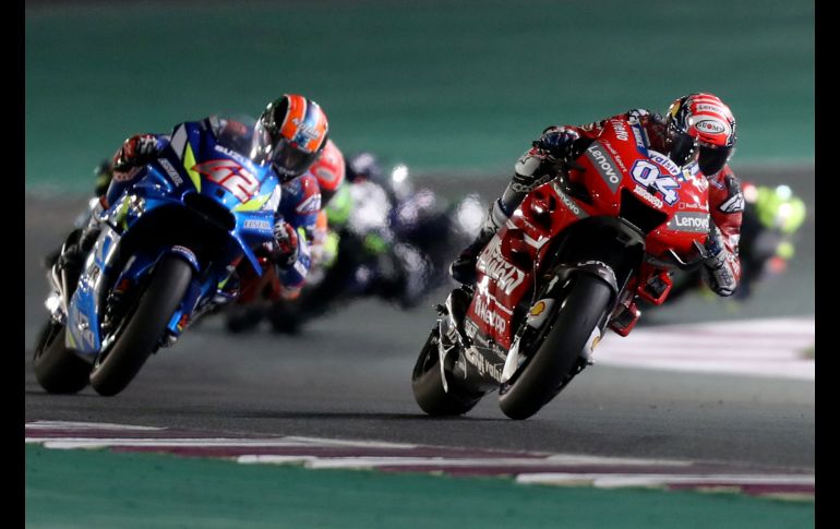 Andrea Dovizioso (d), de Mission Winnow Ducati, y Alex Rins, de Suzuki Ecstar, compiten en el MotoGP de Qatar, disputado en Doha. AFP/K. Jaafar