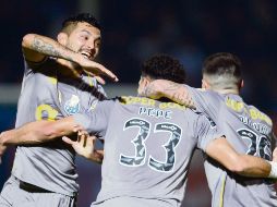 Jesús Corona (izquierda) se úne al festejo tras el primer gol de los Dragones. AFP