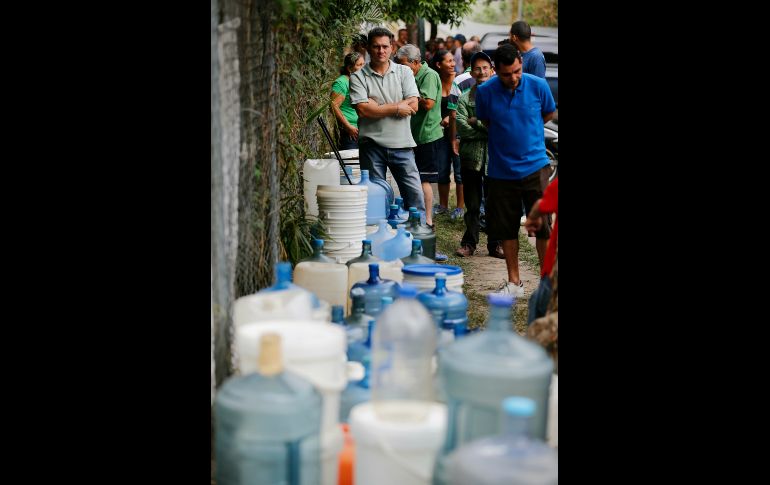 Habitantes aguardan para llenar contenedores con agua de una fuente pública en Caracas, Venezuela, debido a que los apagones han provocado que no haya suministro de agua a hogares. AP/F. Llano