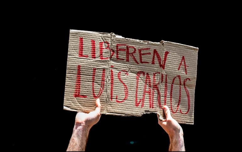 Un manifestante sostiene un cartel durante una movilización para exigir la liberación del periodista. AFP/R. Schemidt