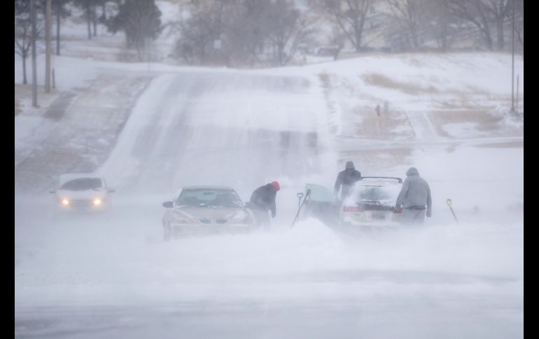 Habitantes intentan liberar un auto atascado en la nieve este jueves en Rapid City, en Dakota del Sur. Más de 25 estados de la zona central de Estados Unidos padecen los efectos del mal clima.
