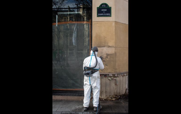 Un trabajador limpia un grafiti.