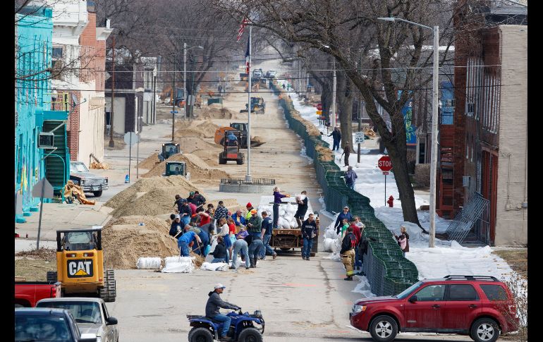 Residentes de Hamburg, en Iowa, colocan costales de arena y montan un muro para contener las aguas.