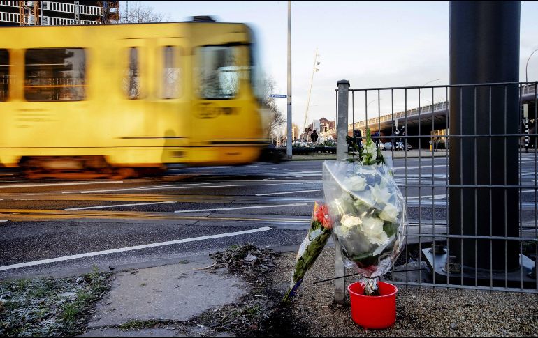 Un tranvía pasa junto a los ramos de flores depositados en el lugar del tiroteo. EFE/R. Van Lonkhuijsen