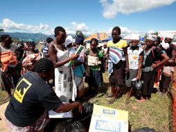 Miembros de un equipo de rescate reparten agua y alimentos a los afectados por el paso del ciclón 