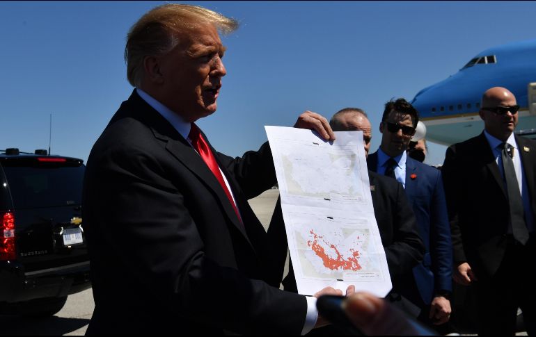 Trump acompañó sus declaraciones con mapas que mostró a los periodistas, al descender del avión presidencial. AFP / N. Kamm