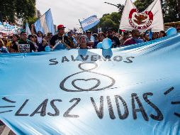 Un manifestante sostiene una enorme manta con el mensaje 