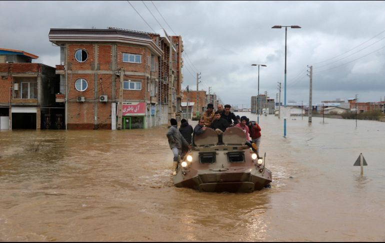 Un vehículo militar traslada a varios damnificados a través de una calle inundada. AP/M. Esmaeilzadeh