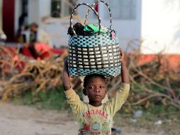 Una niña transporta ropa llegada en un barco en el río Buzi en Sofala, Mozambique. EFE/T. Petinga