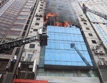 Los bomberos, con largas escaleras, rompieron ventanas para intentar crear vías de escape. Más de una hora después de que empezara el incendio, todavía se veía gente en la planta 13 y 14 pidiendo ayuda. EFE/ M. Alam