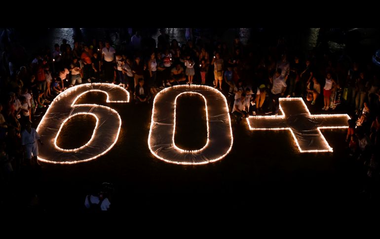 La gente enciende veladoras y forman el número 60+ sign durante La Hora del Planeta en Cali, Colombia. AFP / L. ROBAYO