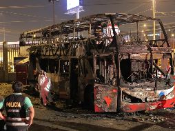 Policías y peritos laboran en el autobús incendiado en la terminal informal de Fiori, en Lima.AFP/L. Gonzales