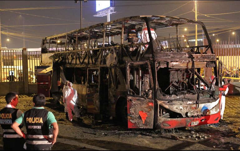 Policías y peritos laboran en el autobús incendiado en la terminal informal de Fiori, en Lima.AFP/L. Gonzales
