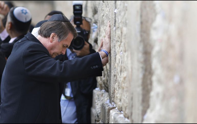 Bolsonaro, con kipá, colocó sus dos manos sobre las antiguas piedras, mientras Netanyahu hacía lo mismo. AFP / M. Kahana