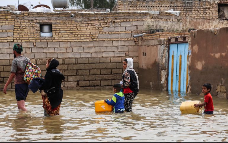 Una familia iraní camina por una calle inundada, en un pueblo cerca de la ciudad de Ahvaz. AFP/TASNIM NEWS