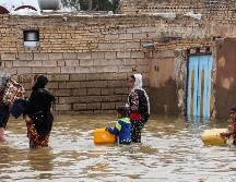 Una familia iraní camina por una calle inundada, en un pueblo cerca de la ciudad de Ahvaz. AFP/TASNIM NEWS
