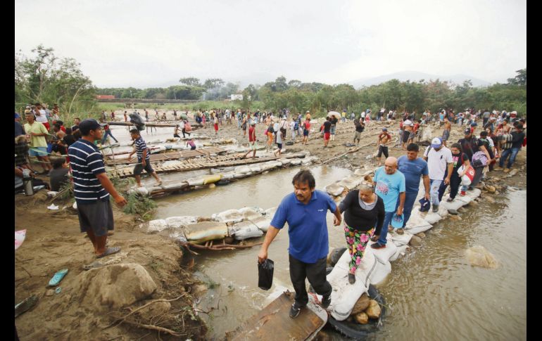 Decenas de personas cruzan el Río Tachira, en la frontera entre Venezuela y Colombia, para huir del régimen chavista. AP