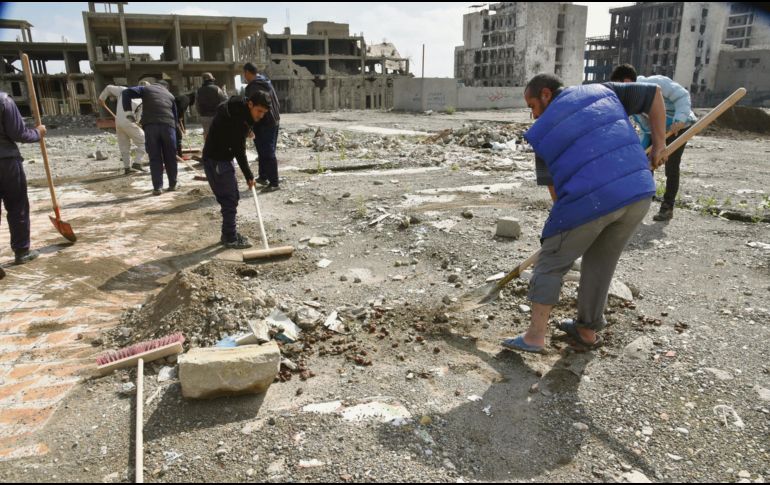 Voluntarios levantan los escombros de calles y construcciones arruinadas por enfrentamientos. EFE