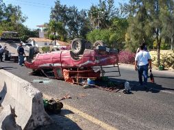 La camioneta queda volcada sobre su toldo a la mitad de la vía, mientras que el autobús se impacta del lado del piloto contra el muro de contención. ESPECIAL