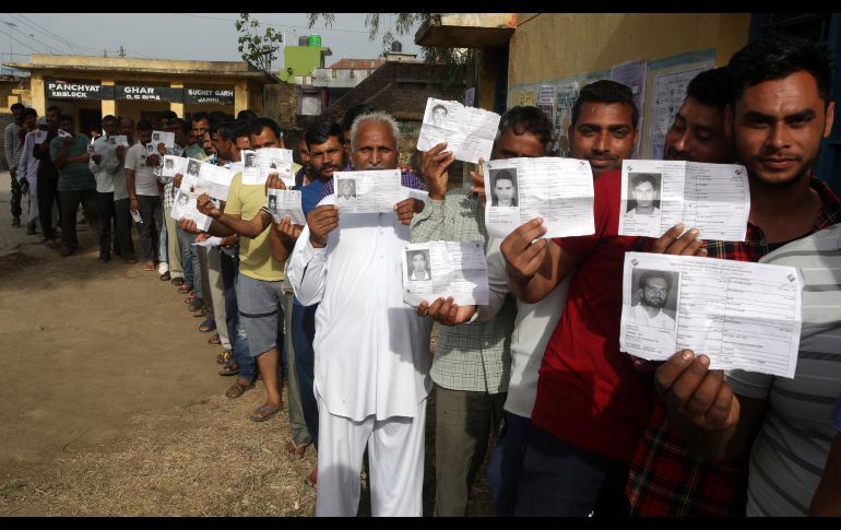 Hombres muestran sus documentos de identidad mientras hacen fila para votar en Suchetgarh en Ranbir Singh Pora. EFE/J.Singh