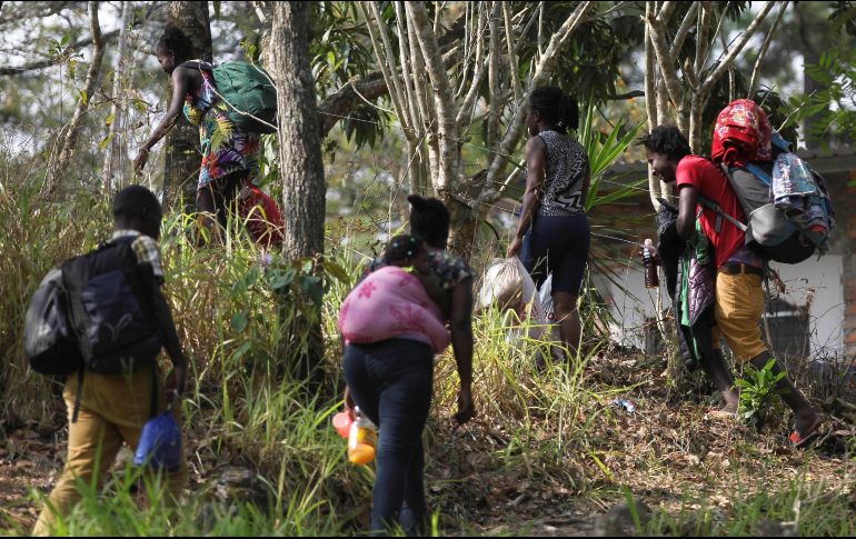 Migrantes haitianos caminan por un sendero para evitar el punto migratorio de la Aduana de Agua Caliente, en Honduras. EFE/G. Amador