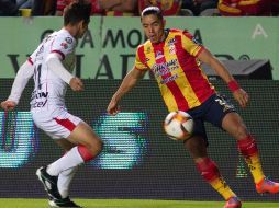 El jugador de Morelia Efrain Velarde (d), disputa el balón con Isaac Brizuela (i), de Chivas, este sábado. EFE/L. Granados