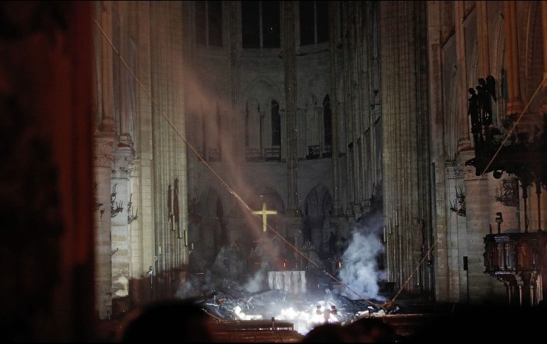 Luego de sofocar los principales focos de incendio, los bomberos lograron entrar a la Catedral, en uno de los instantes de mayor emotividad de la jornada. AFP/P. Wojazer