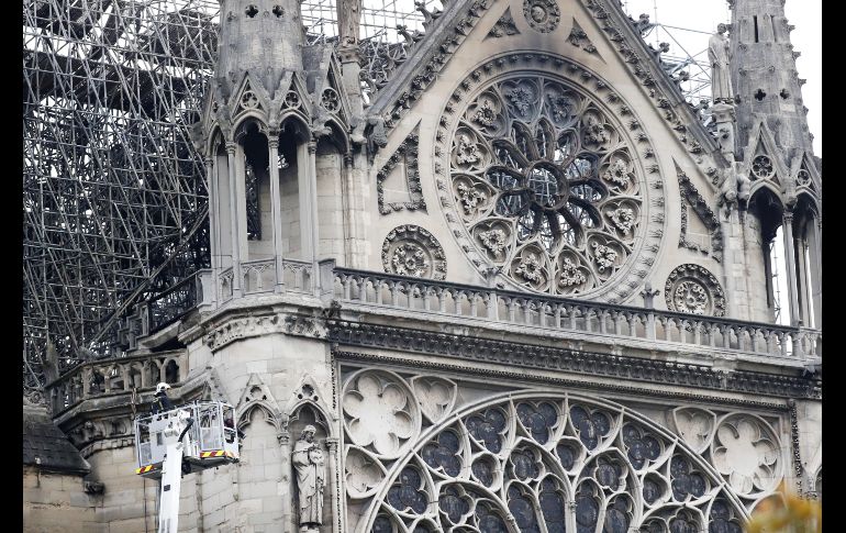 Un bombero trabaja en un elevador junto al andamiaje que cubre parte de la catedral de Notre Dame. Los bomberos declararon el martes que triunfaron en una batalla de más de 12 horas para extinguir el fuego