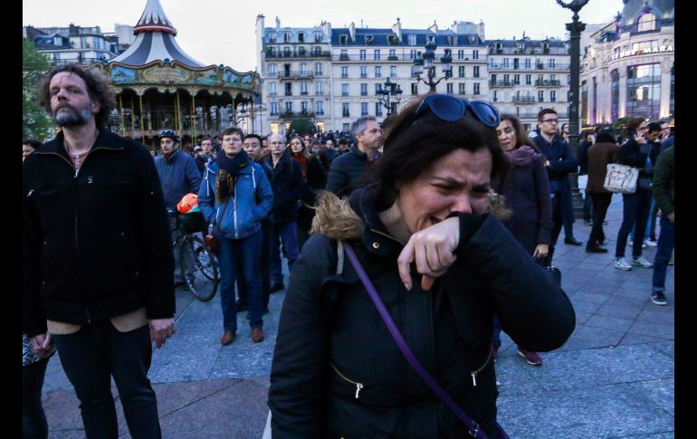 Una mujer llora al ver el siniestro. AFP