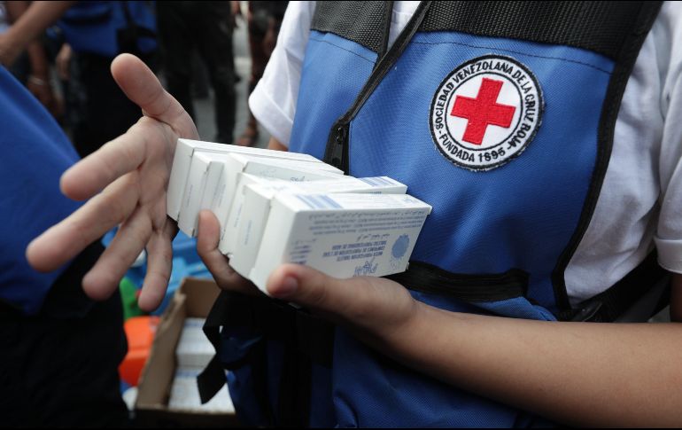 Miembros de la Cruz Roja reparten pastillas potabilizadoras del primer cargamento de ayuda humanitaria de ese movimiento que llegó este martes a Caracas. EFE/R. Peña