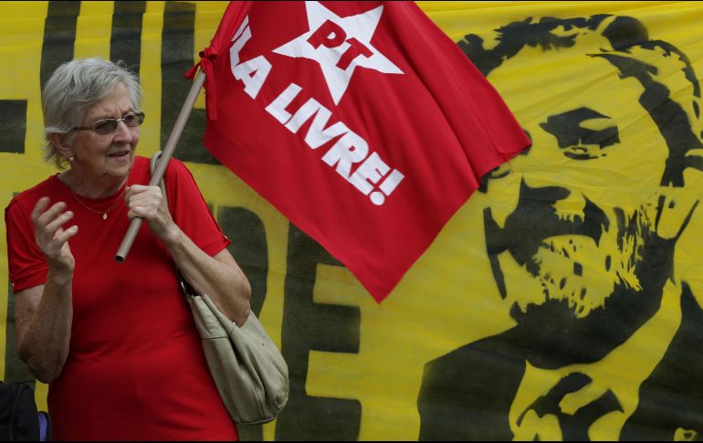 Una mujer sostiene una bandera del Partido de los Trabajadores durante una demostración de apoyo a Lula afuera de la Suprema Corte de Justicia. AP/E. Peres