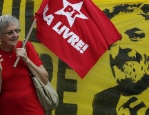Una mujer sostiene una bandera del Partido de los Trabajadores durante una demostración de apoyo a Lula afuera de la Suprema Corte de Justicia. AP/E. Peres