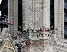 Trabajadores con cascos blancos hablaban con los bomberos ante el monumento, mientras otros apuntalaban la catedral del siglo XII. Ya había varias grúas alrededor de la estructura. AP / T. Camus