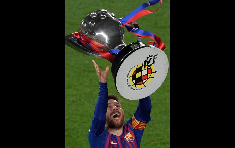 Lionel Messi levanta el trofeo de la liga al terminar el partido contra el Levante donde él mismo anotó el único tanto. AFP  / Ll. Gene