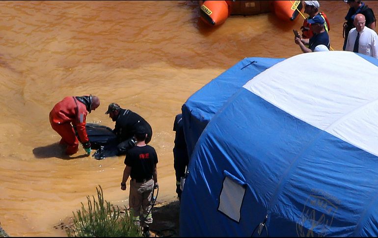 Un buzo y un investigador sacan una maleta de un lago tóxico, parte de una mina de pirita de cobre, en la población de Mitsero. AP/P. Karadjias