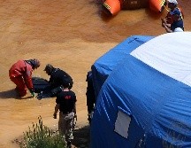 Un buzo y un investigador sacan una maleta de un lago tóxico, parte de una mina de pirita de cobre, en la población de Mitsero. AP/P. Karadjias