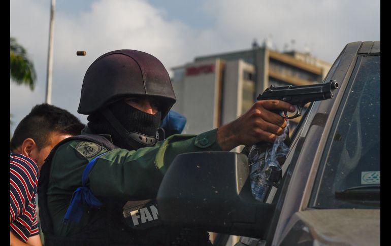 Un militar rebelde apunta su arma durante los enfrentamientos. AFP/F. Parra