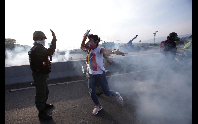 Una opositora al gobierno de Nicolás Maduro la choca con un militar rebelde durante enfrentamientos con soldados en Caracas, Venezuela.