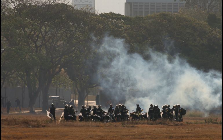 Elementos de la Guardia Nacional leales a Maduro lanzan gas lacrimógeno desde la base aérea militar La Carlota, en Caracas. AP/F. Llano
