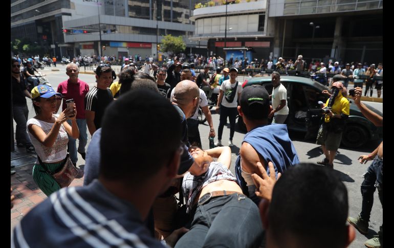 Personas trasladan a una mujer herida de bala en el estómago durante una manifestación contra Maduro a la altura del ministerio de Transporte, en la Avenida Francisco de Miranda de Caracas. EFE/M. Gutiérrez