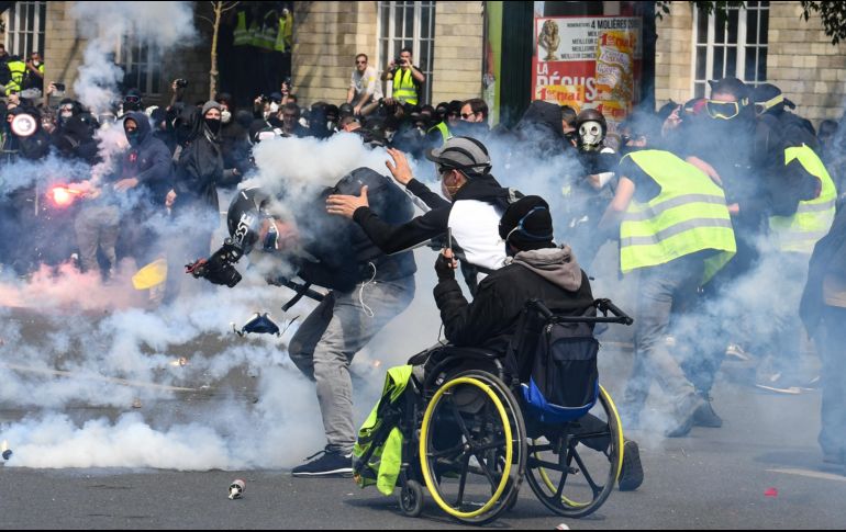 Un camarógrafo recibe el impacto de una lata de gas lacrimógeno. AFP/A. Jocard
