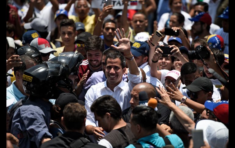Juan Guaidó saluda a simpatizantes antes de dar un discurso, un día después de su llamado al levantamiento militar. AFP/F. Parra