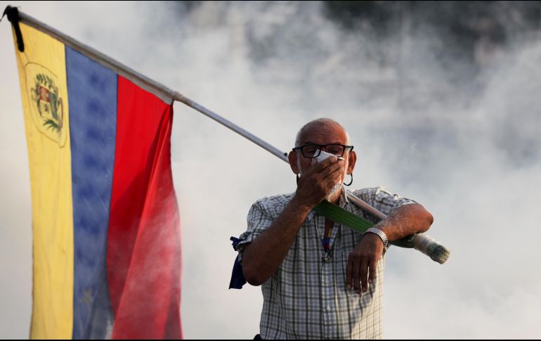 Un manifestante opositor a Nicolás Maduro sostiene una bandera de Venezuela en medio de una manifestación. AP/B. Vergara