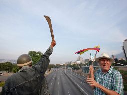 Un manifestante opositor al gobierno de Maduro levanta un machete durante una marcha. AP/B. Vergara