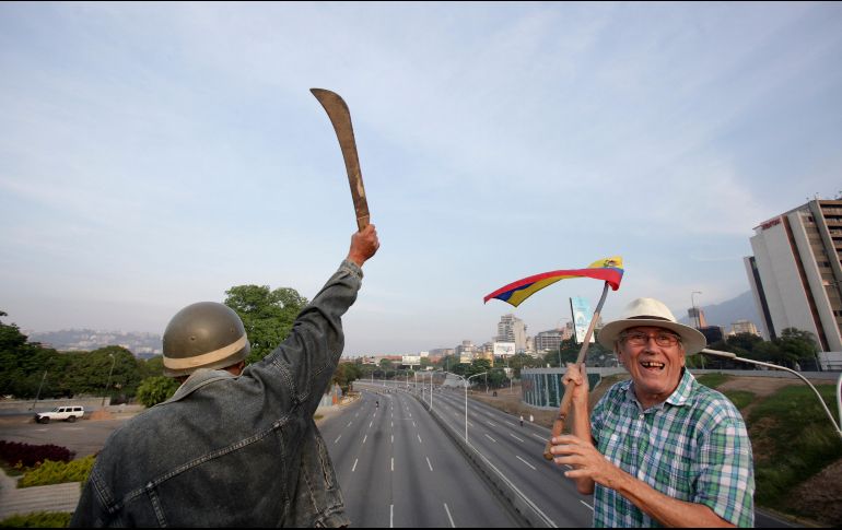 Un manifestante opositor al gobierno de Maduro levanta un machete durante una marcha. AP/B. Vergara
